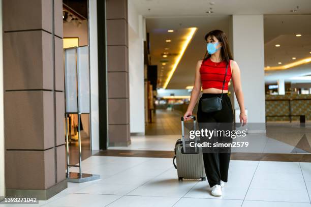 junge asiatische reisende mit gepäckeinkauf im duty-free-shop am flughafen - airport shop stock-fotos und bilder