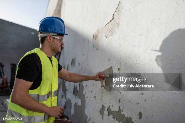 construction worker removes paint from a facade - mason bricklayer stock pictures, royalty-free photos & images