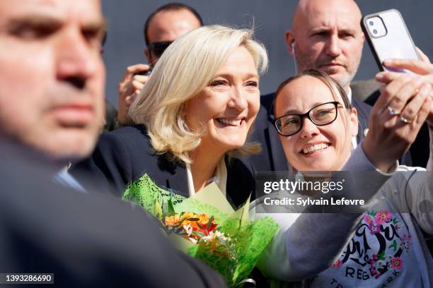 French far-right National Rally candidate Marine Le Pen poses with supporters as she leaves a polling station after casting her ballot for the 2nd...