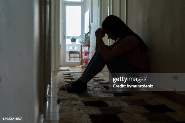 sad woman sitting corridor floor - anonymous silhouette stock pictures, royalty-free photos & images