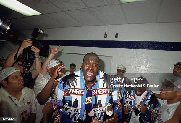 Center Shaquille O'Neal of the Los Angeles Lakers celebrates with teammates Kobe Bryant and Devean George in the locker room after winning Game Four...
