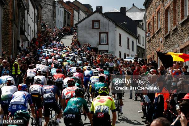 General view of the peloton passing through the Côte de Saint-Roch in Houffalize City while fans cheer during the 108th Liege - Bastogne - Liege 2022...