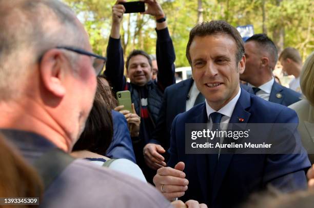 Emmanuel Macron salutes voters as he leaves after voting on April 24, 2022 in Le Touquet-Paris-Plage, France. Emmanuel Macron and Marine Le Pen were...