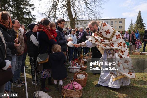Abbot Daniil Irbits, Prior of the Russian Orthodox St. George Monastery, blesses local Russians and recently arrived Ukrainian refugees at the...