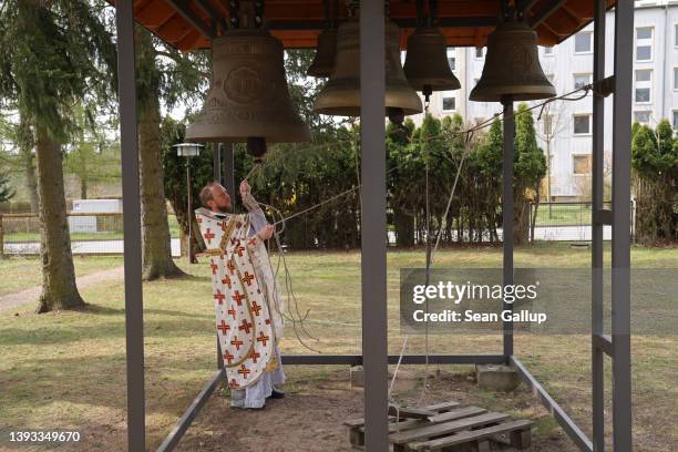 Abbot Daniil Irbits, Prior of the Russian Orthodox St. George Monastery, rings bells prior to leading local Russians and recently arrived Ukrainian...