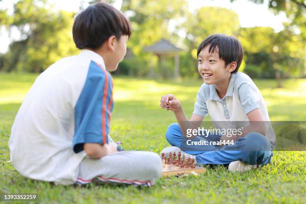 children started the classic a chess match outdoors - kids playing chess stock pictures, royalty-free photos & images