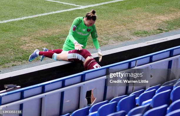 Mackenzie Arnold helps teammate Kate Longhurst of West Ham United up after a challenge with Sanne Troelsgaard of Reading during the Barclays FA...