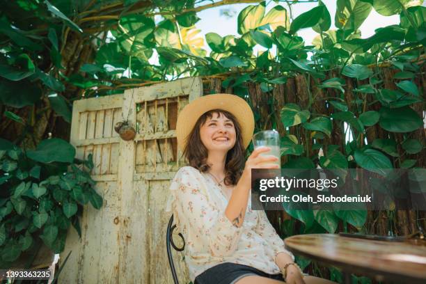 woman in straw hat drinking lemonade on backyard - drinking in yard stock pictures, royalty-free photos & images