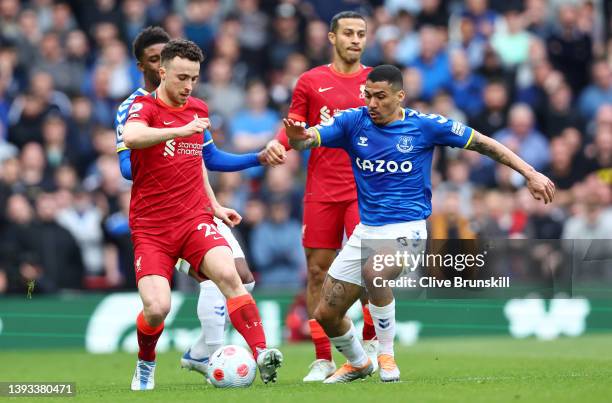 Diogo Jota of Liverpool is challenged by Allan of Everton during the Premier League match between Liverpool and Everton at Anfield on April 24, 2022...