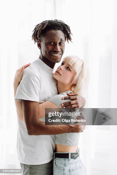 bounding couple, man and woman standing and hugging together. close relationship. black and white. female looking at boyfriend - clothing too small stock pictures, royalty-free photos & images