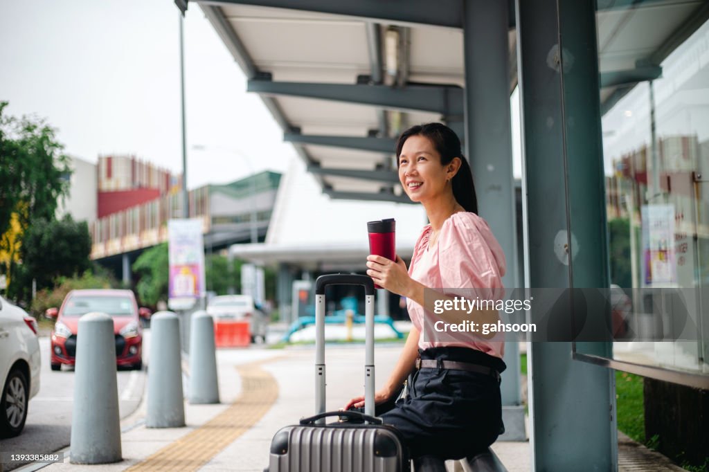 Businesswoman with luggage waiting in taxi stand