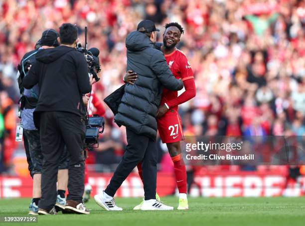 Juergen Klopp celebrates with Divock Origi of Liverpool after their sides victory during the Premier League match between Liverpool and Everton at...