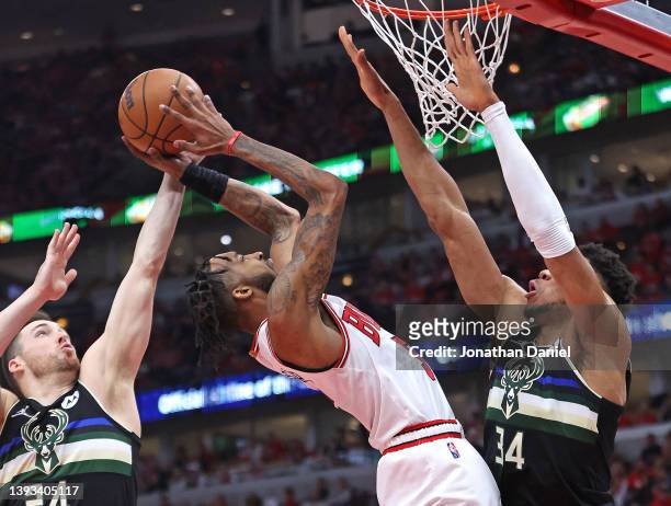 Derrick Jones Jr. #5 of the Chicago Bulls tries to get off a shot between Pat Connaughton and Giannis Antetokounmpo of the Milwaukee Bucks during...