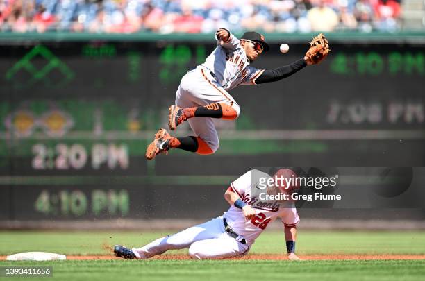 Lane Thomas of the Washington Nationals steals second base in the second inning as the throw gets by Thairo Estrada of the San Francisco Giants at...