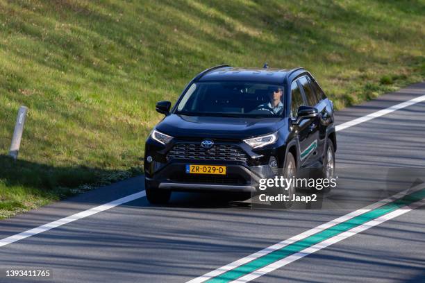 dutch black 2019 hybrid toyota rav4 driving on the n36 - hybrid vehicle stock pictures, royalty-free photos & images