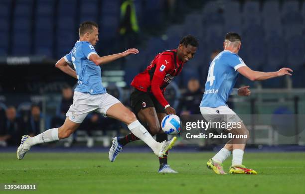 Rafael Leao of AC Milan is challenged by Lucas Leiva and Patric of SS Lazio during the Serie A match between SS Lazio and AC Milan at Stadio Olimpico...