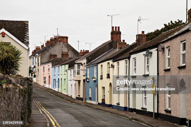 street of colourful houses in tenby against overcast sky, uk - tenby wales stock pictures, royalty-free photos & images