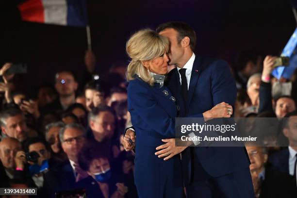 France's centrist incumbent president Emmanuel Macron kisses his wife Brigitte Macron after adressing voters in front of the Eiffel Tower after...