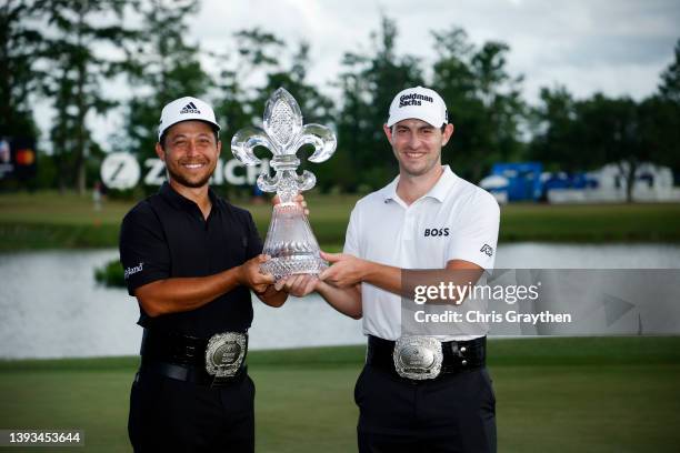 Xander Schauffele and Patrick Cantlay pose with the trophy after putting in to win on the 18th green during the final round of the Zurich Classic of...