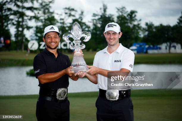 Xander Schauffele and Patrick Cantlay pose with the trophy after putting in to win on the 18th green during the final round of the Zurich Classic of...