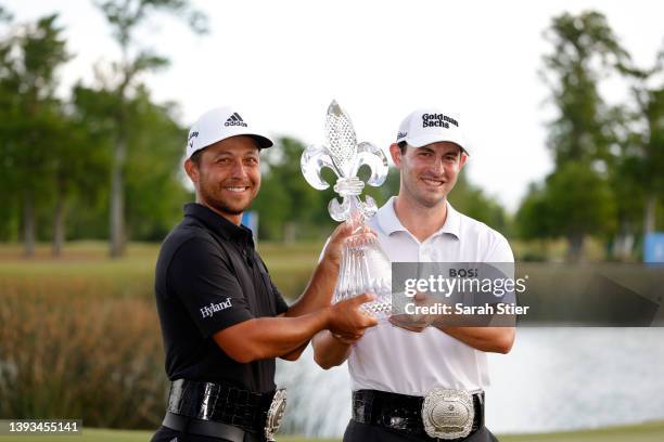 Xander Schauffele and Patrick Cantlay pose with the trophy after putting in to win on the 18th green during the final round of the Zurich Classic of...