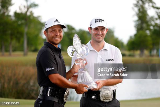 Xander Schauffele and Patrick Cantlay pose with the trophy after putting in to win on the 18th green during the final round of the Zurich Classic of...