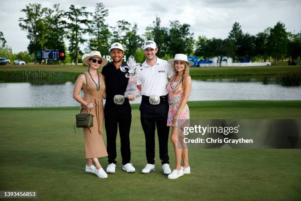 Patrick Cantlay pose with his partner Nikki Guidish and Xander Schauffele and his wife Maya after their team putted in to win on the 18th green...