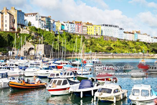 tenby harbour at high tide with mooring boats and iconic colourful terraced houses, uk - new zealand beach house stock pictures, royalty-free photos & images