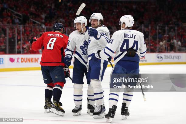 Ilya Lyubushkin of the Toronto Maple Leafs celebrates his goal with teammate Auston Matthews in front of Alex Ovechkin of the Washington Capitals...