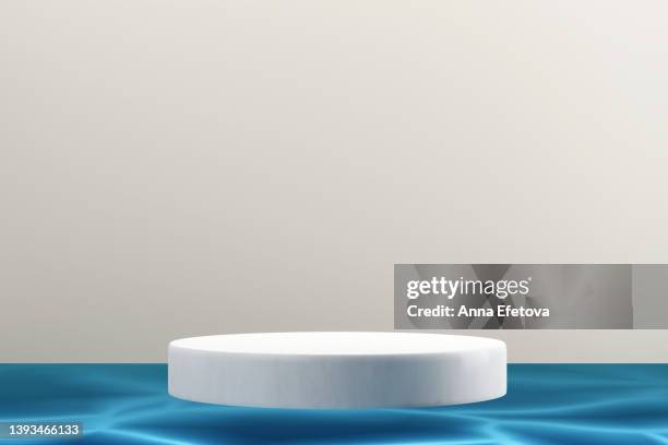 white ceramic podium in blue water against a gray wall. minimalist 3d background for your product demonstration - pedestal stock pictures, royalty-free photos & images