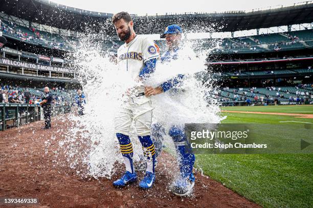 Jesse Winker of the Seattle Mariners is doused with water after his RBI single to score Adam Frazier to beat the Kansas City Royals 5-4 during the...