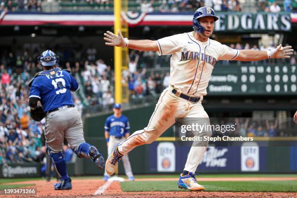 Adam Frazier of the Seattle Mariners scores the winning run on an RBI single by Jesse Winker to beat the Kansas City Royals 5-4 during the 12th...