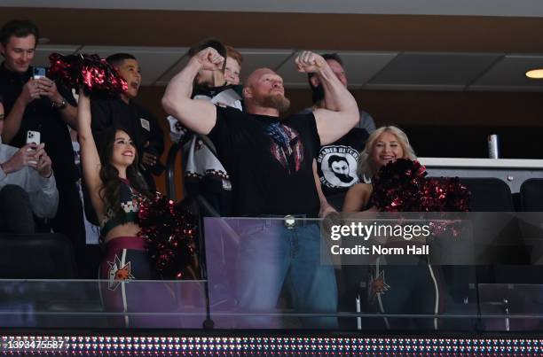 Brock Lesnar, former WWE champion and UFC champion, flexes for the crowd during a game between the Arizona Coyotes and Washington Capitals at Gila...