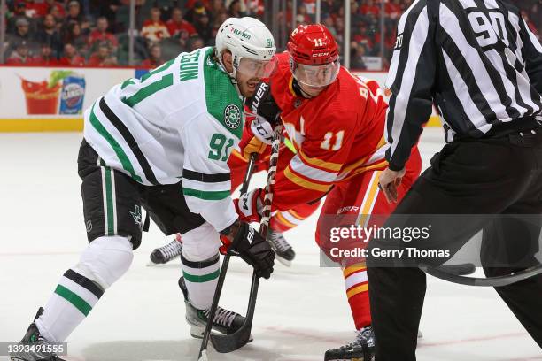 Mikael Backlund of the Calgary Flames battles against Tyler Seguin of the Dallas Stars at Scotiabank Saddledome on April 21, 2022 in Calgary,...