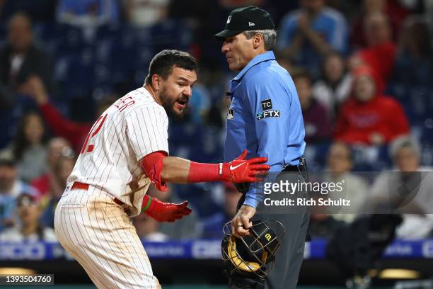 Kyle Schwarber of the Philadelphia Phillies argues with home plate umpire Angel Hernandez after being called out on a third strike during the ninth...