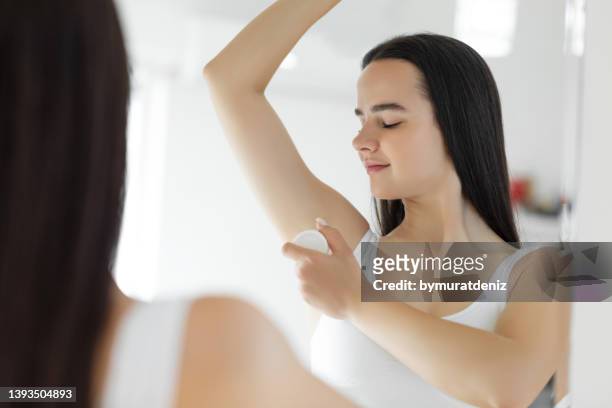 woman using roller deodorant - deodorant stock pictures, royalty-free photos & images