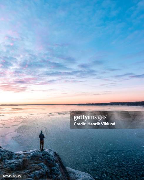 person admires the view of a frozen lake - stockholm sunset stock pictures, royalty-free photos & images