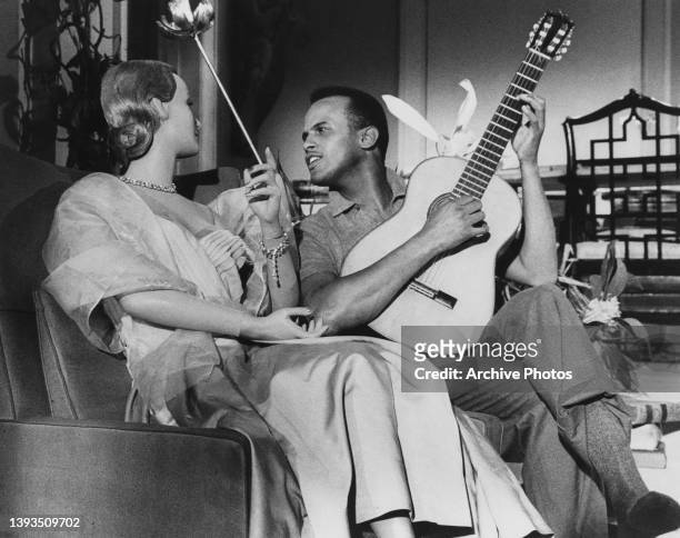 Swedish-American actress Inger Stevens and American singer-songwriter and civil rights activist Harry Belafonte, playing an acoustic guitar in a...