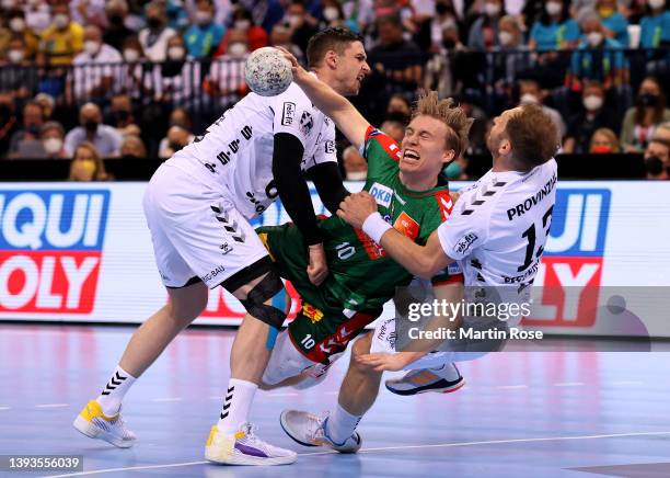 Hendrik Pekeler and Steffen Weinhold of THW Kiel challenge Gisli Kristjansso of SC Magdeburg during the REWE Final 4 final match between THW Kiel and...