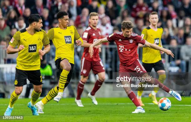 Thomas Mueller of FC Bayern Muenchen is challenged by Jude Bellingham of Borussia Dortmund during the Bundesliga match between FC Bayern München and...