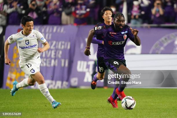 Peter Utaka of Kyoto Sanga in action under pressure from Mitsuki Saito of Gamba Osaka during the J.LEAGUE Meiji Yasuda J1 7th Sec. Match between...