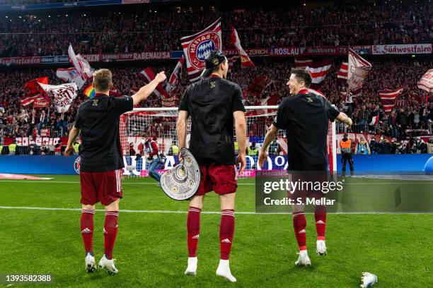 Joshua Kimmich of FC Bayern Muenchen and Leon Goretzka of FC Bayern Muenchen and Robert Lewandowski of FC Bayern Muenchen in front of the fans while...