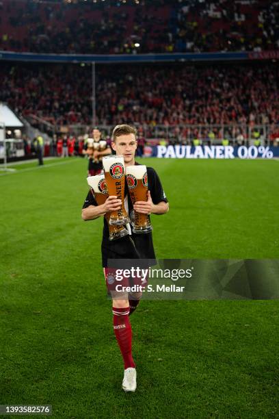 Joshua Kimmich of FC Bayern Muenchen carrying beer while celebrating the win of the 10th german championship in a row after the Bundesliga match...