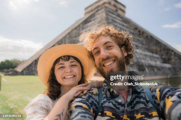 paar macht selfie auf dem hintergrund der chichen itza pyramide in mexiko - merida mexico stock-fotos und bilder