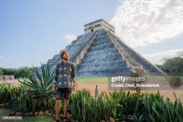 man on the background of chichen itza pyramid in mexico - chichen itza stockfoto's en -beelden