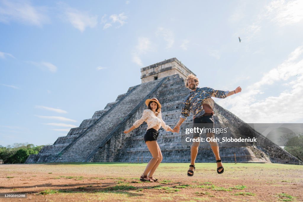 Couple on the background of Chichen Itza pyramid in Mexico