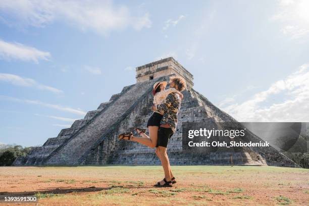 couple on the background of chichen itza pyramid in mexico - chichen itza stockfoto's en -beelden