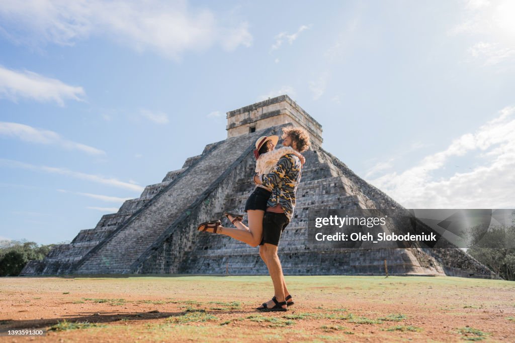 Couple on the background of Chichen Itza pyramid in Mexico