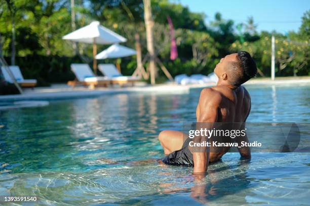 indonesian traveller relaxing in the poolside - next to stock pictures, royalty-free photos & images