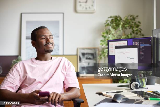 businessman day dreaming by desk at home office - african american man day dreaming stock pictures, royalty-free photos & images